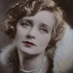 Classic vintage portrait of a woman wearing a fur coat and pearl necklace with red lips.